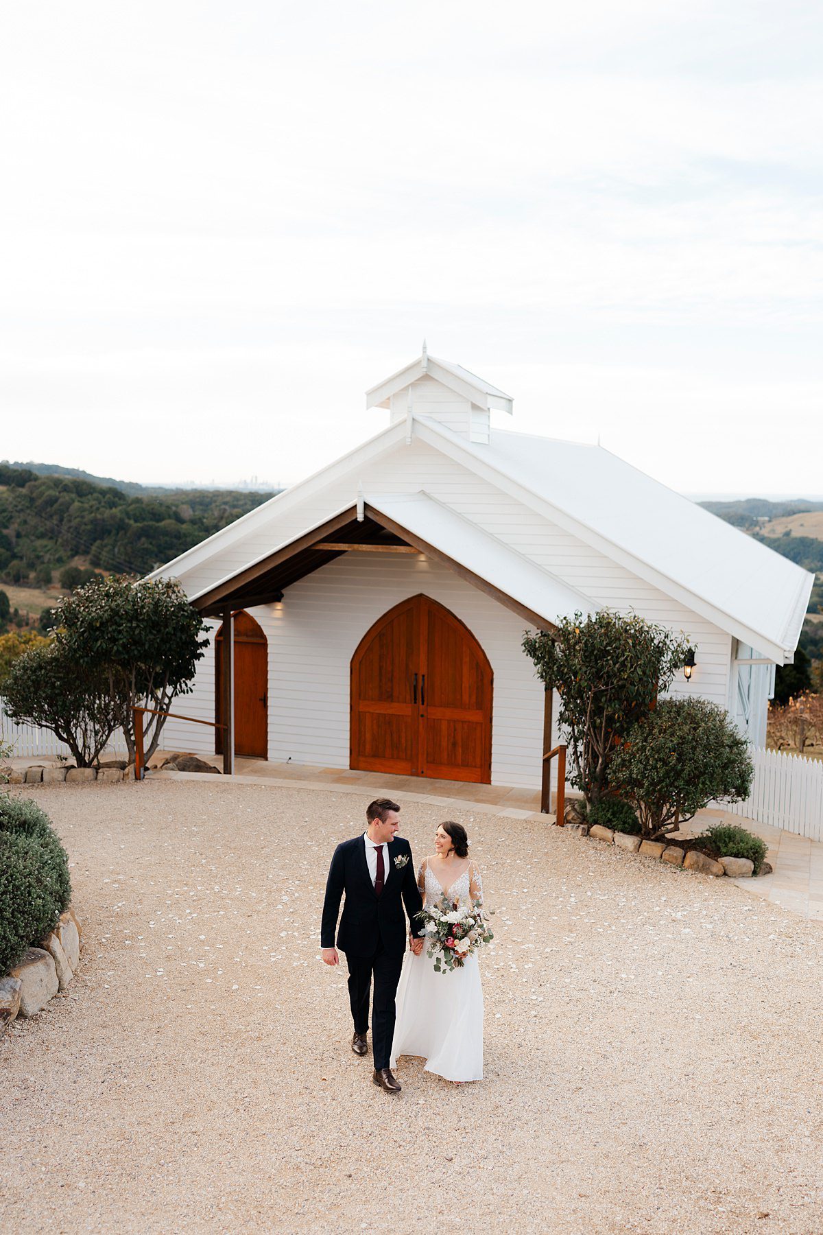 Married couple walking in front of the Summergrove Estate Wedding Chapel