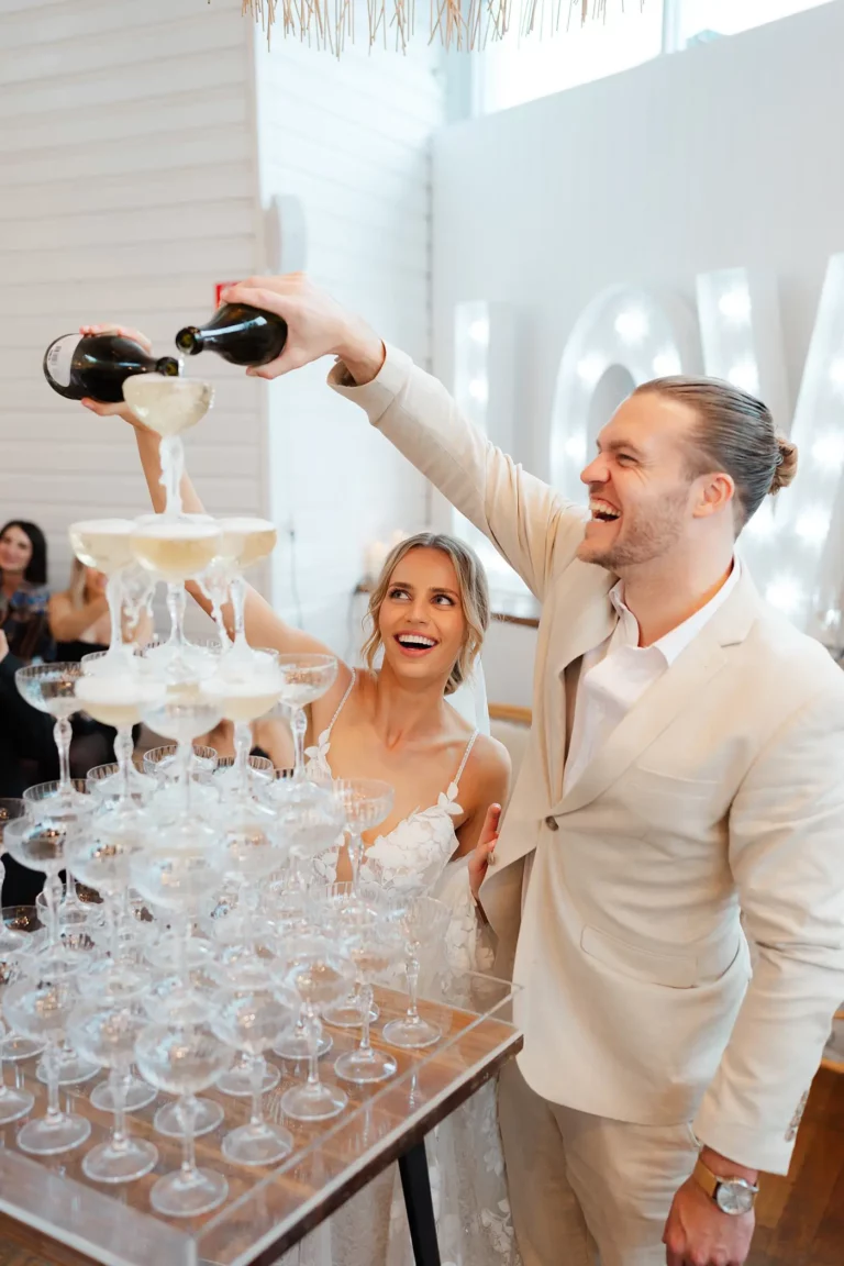 bride and groom enjoying the champagne towers during their wedding day at ancora in tweed