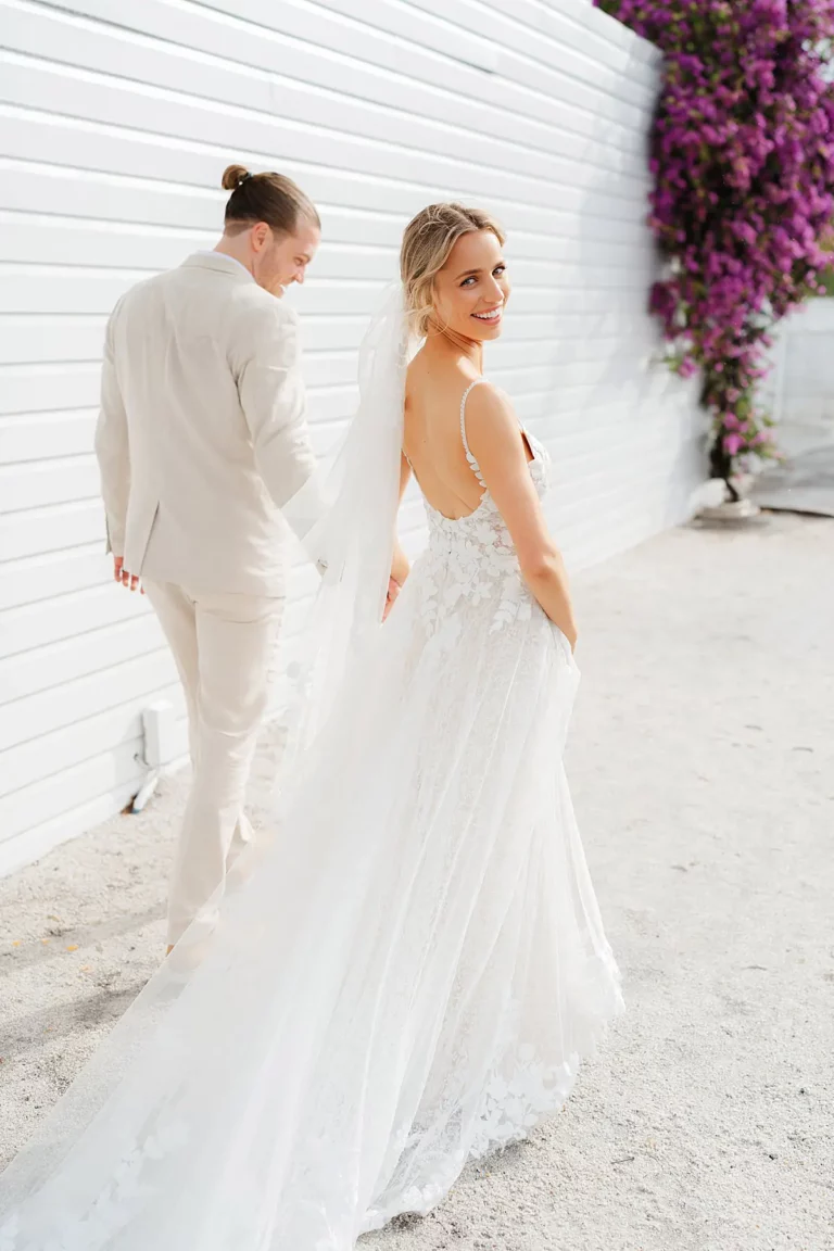 bride and groom walking away with the bride looking back at the camera