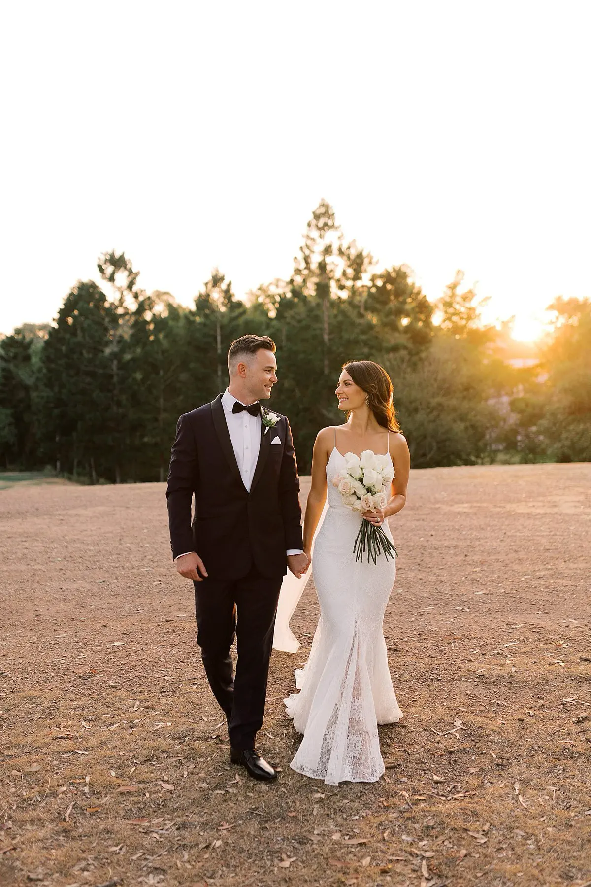 Bride and Groom walking together during the portraits at sunset on the gold caost