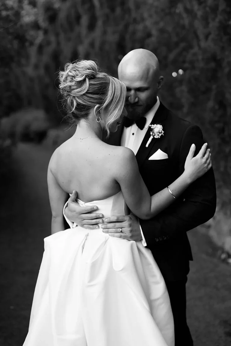 bride and groom cuddles at evergreen garden venue