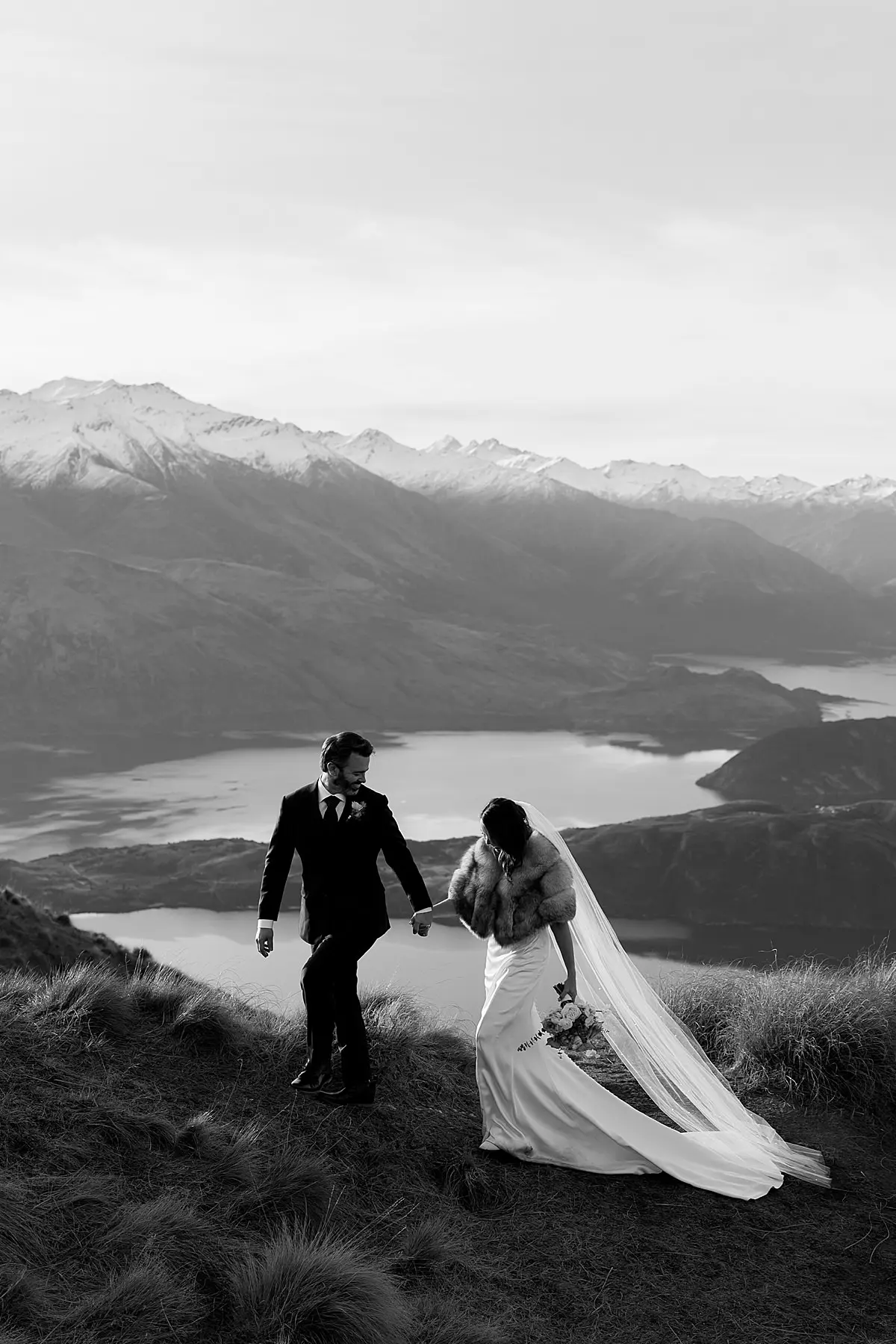 Bride and Groom walking on a mountain in Wanaka New Zealand during their winter wedding